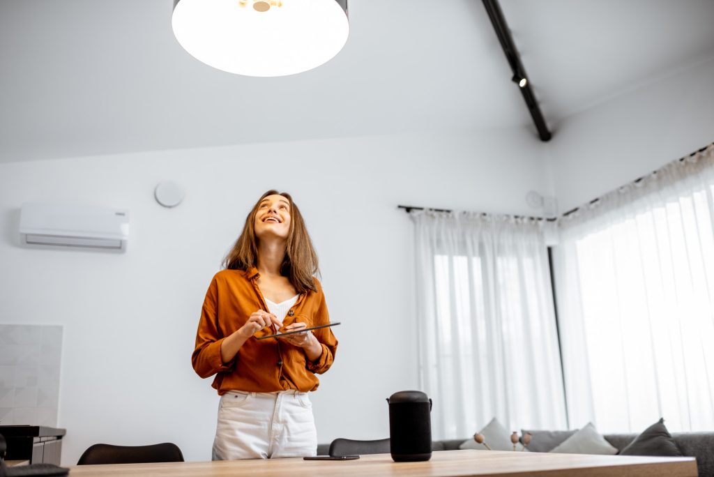 Woman controlling light with a smart home at home